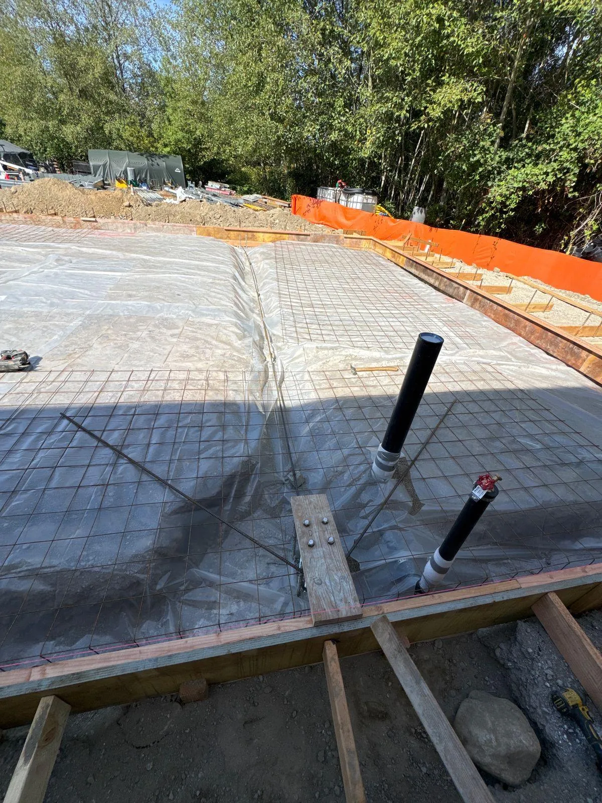 Rebar and wood formwork across the shop foundation footprint before concrete placement.